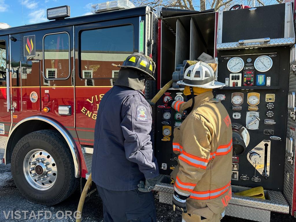 Assistant Chief Mike Peck showing Firefighter/EMT Ryan Huntsman how to operate the Engine 141 pump panel - 03/19/23