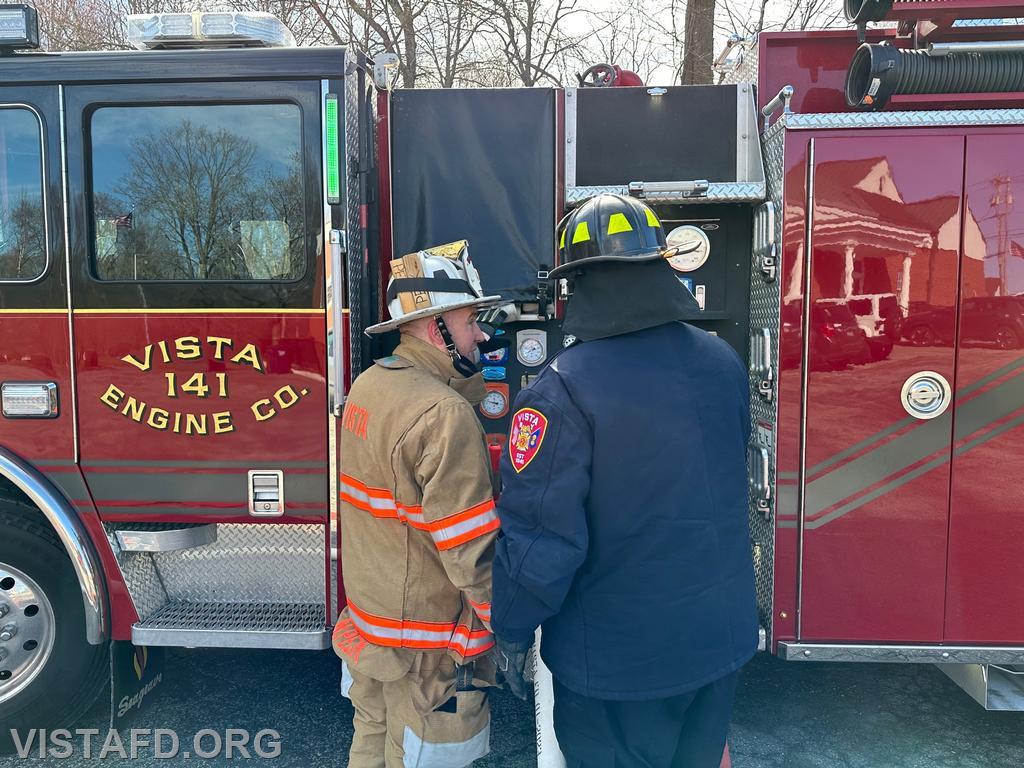 Assistant Chief Mike Peck showing Firefighter/EMT Ryan Huntsman how to operate the Engine 141 pump panel - 04/02/23