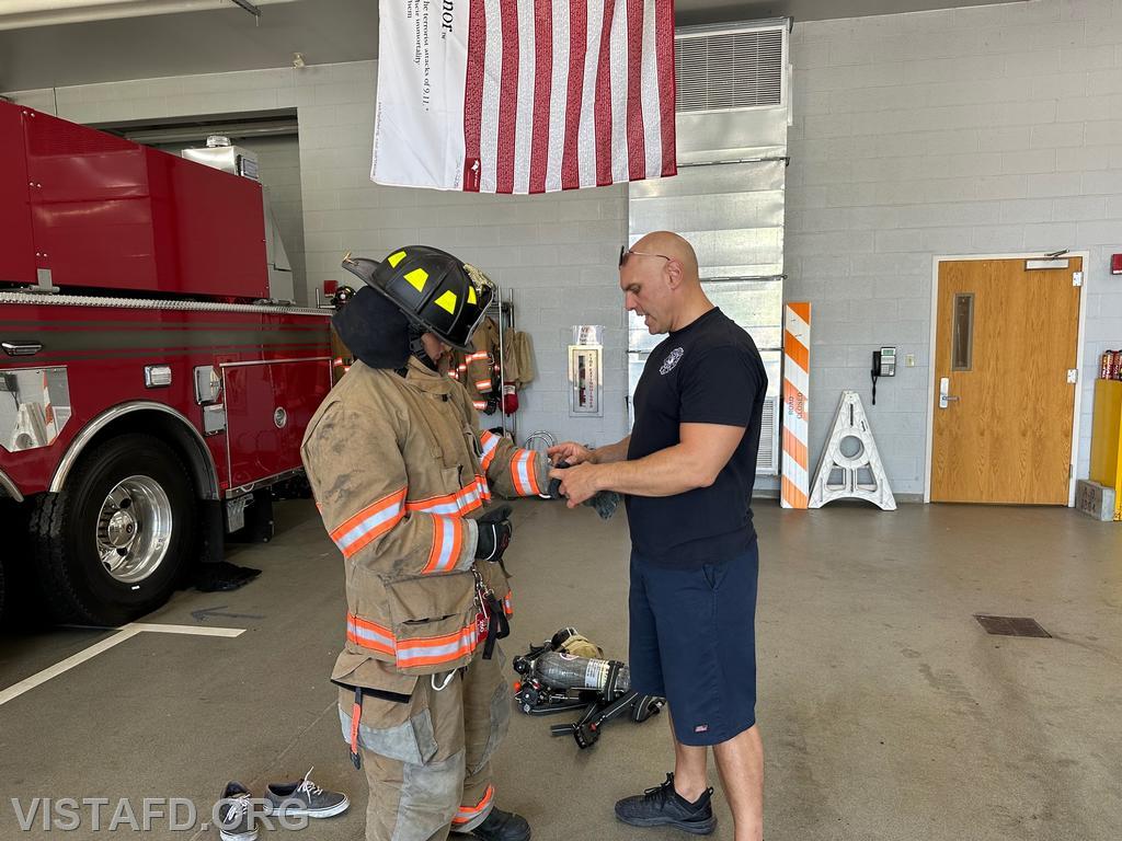 Captain Marc Baiocco going over firefighting gear with Probationary Firefighter Teddy Goetz - 09/03/23