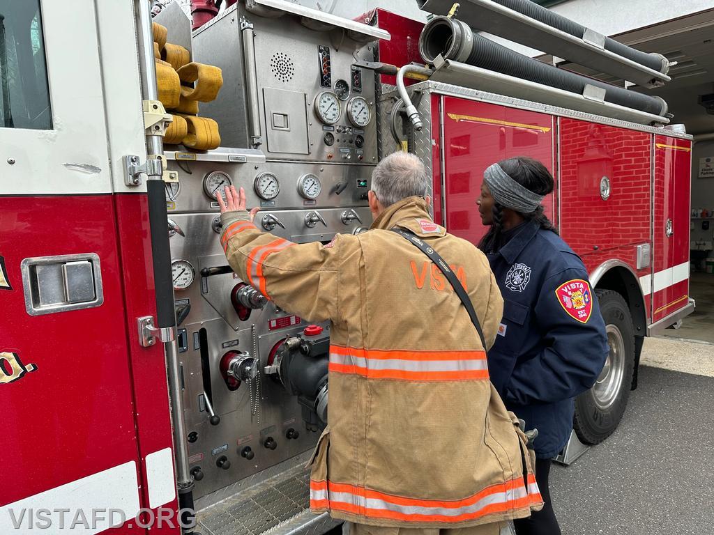 Firefighter/EMT Candidate Andy Korman practicing how to use the Engine 143 pump panel as Firefighter Judith Le Gall looks on - 05/05/24