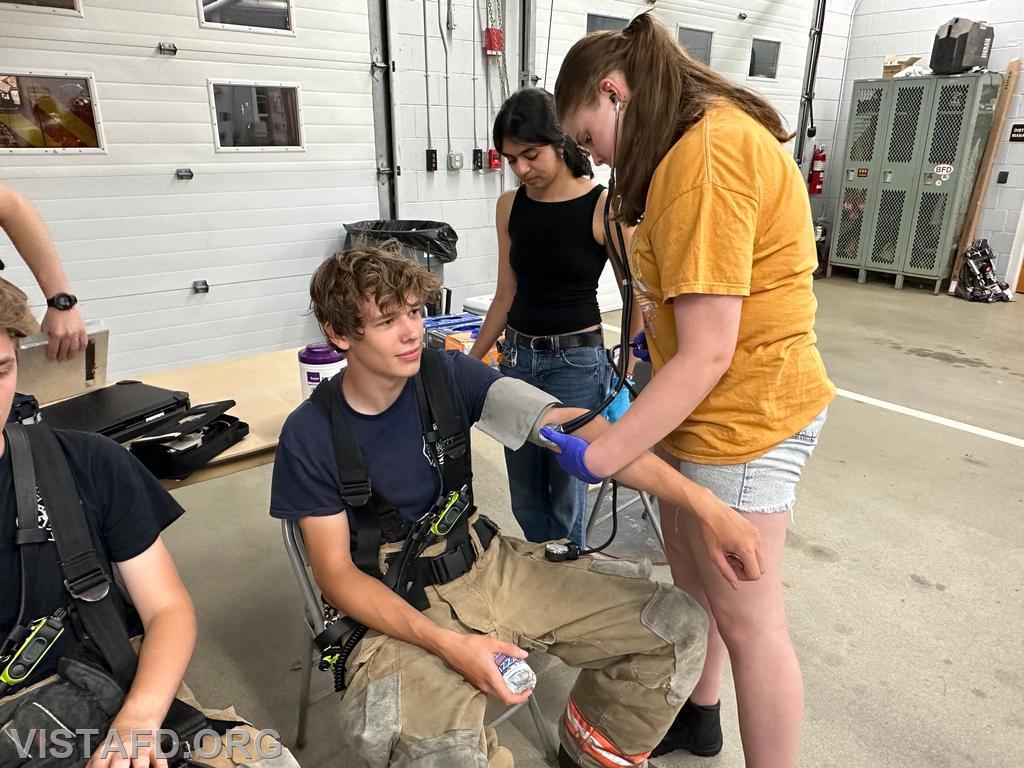 Probationary EMT Candidate Amanda Aalto conducting rehab operations on Firefighter Guillaume Pestie as EMT Savannah Phillips looks on - 08/12/24