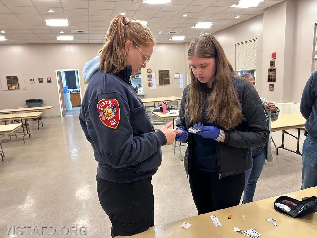 Probationary EMT Amanda Aalto practicing how to use the glucometer on Foreman Isabel Fry - 10/14/24