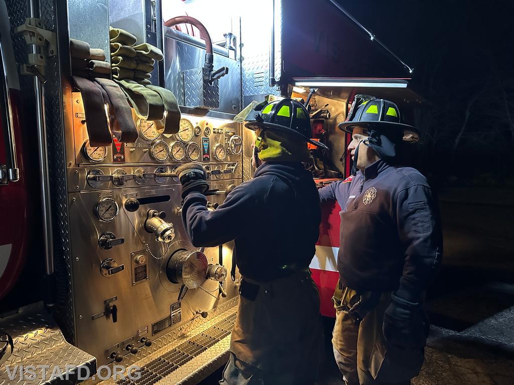 Probationary Firefighter Dan Hochman operating the Engine 142 pump panel during a hydrant service as Lt. Dan Castelhano looks on - 11/25/24