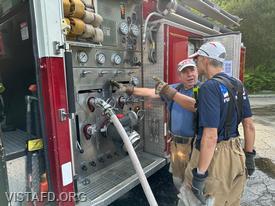 Foreman Brian Sferra going over how to operate the Engine 143 pump panel with FF/EMT Andy Korman