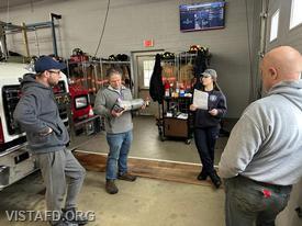 Foreman Kyla Whalen discussing the SCBA cylinder with Vista Fire Department personnel during the "Firefighter Skills Class"